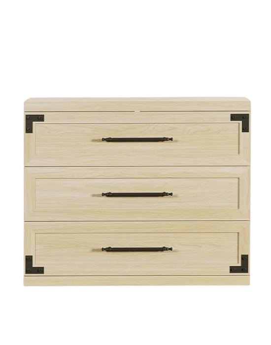 Grey wooden dresser with three drawers and black metal handles, set against a black background.
