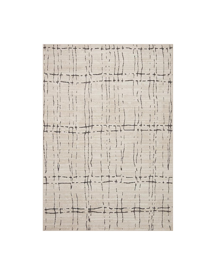 A cream-colored area rug with a black geometric pattern of irregular lines and dashes arranged in a grid-like fashion.