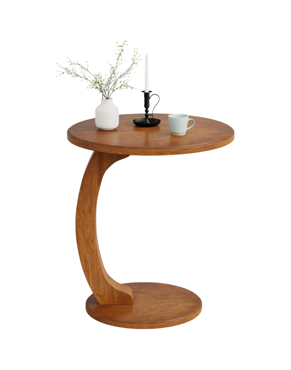 Round wooden side table with a black candle holder with a white candle, a white mug, and a white vase with branches of white flowers.