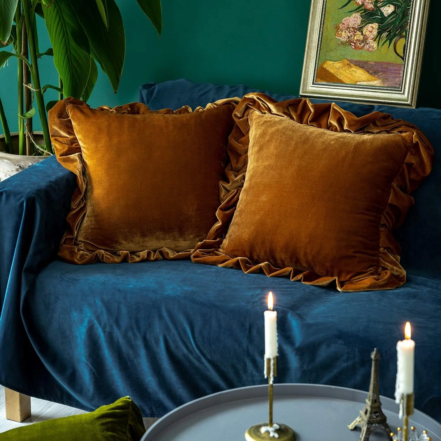 Two rich yellow ruffled pillows on a blue couch
