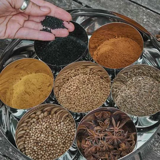 Assorted Ayurvedic spices and seeds in metal bowls, representing digestion, agni, and foundational Ayurvedic principles