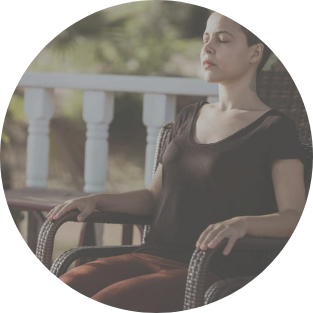 Person sitting quietly outdoors with eyes closed, embodying the calm and grounded state supported by 5NP ear acupuncture sessions with Mel Rolfes.