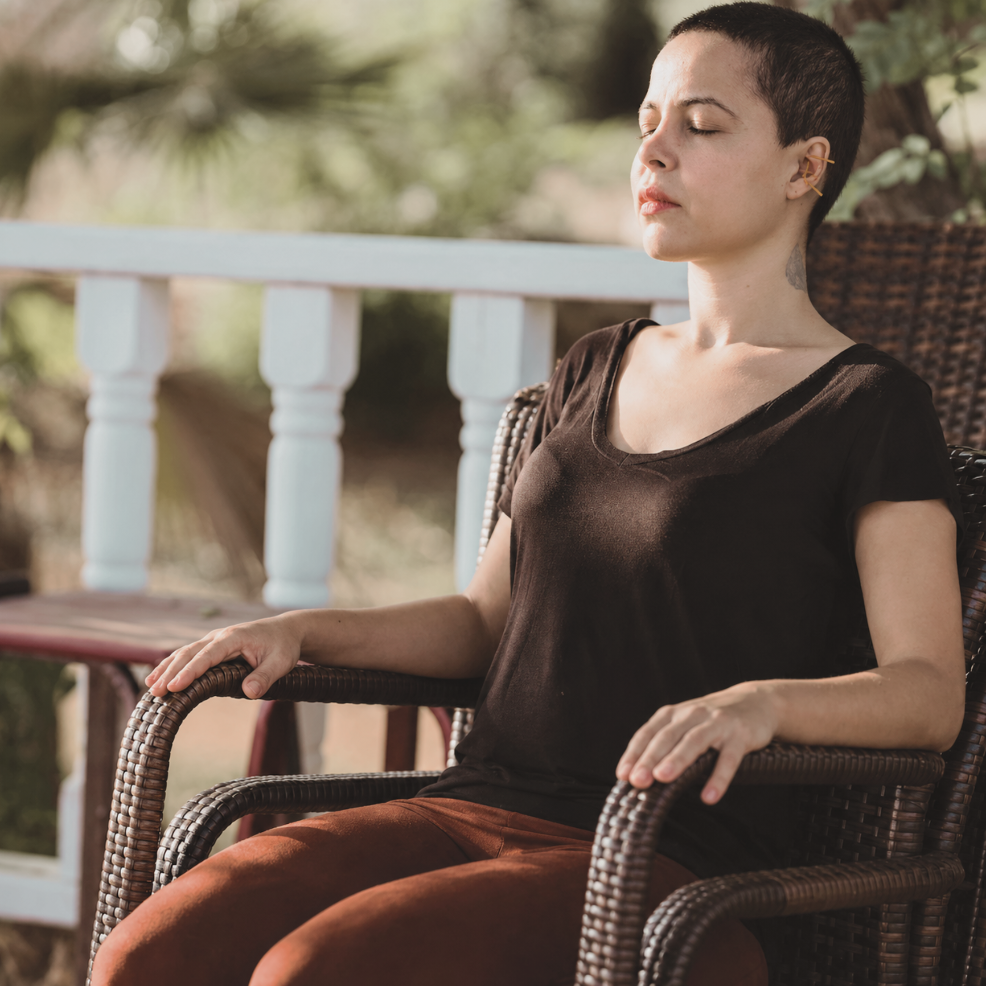 person sitting in a chair with eyes closed receiving ear acupuncture treatment
