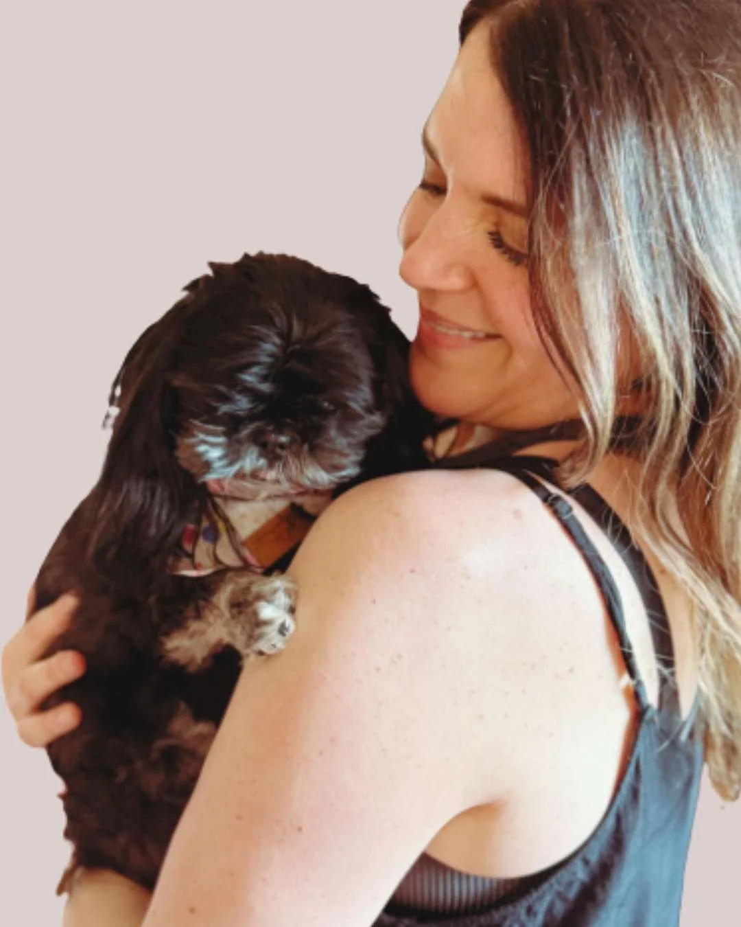 Mel Rolfes smiling and holding her dog, yoga teacher and mind-body practitioner.