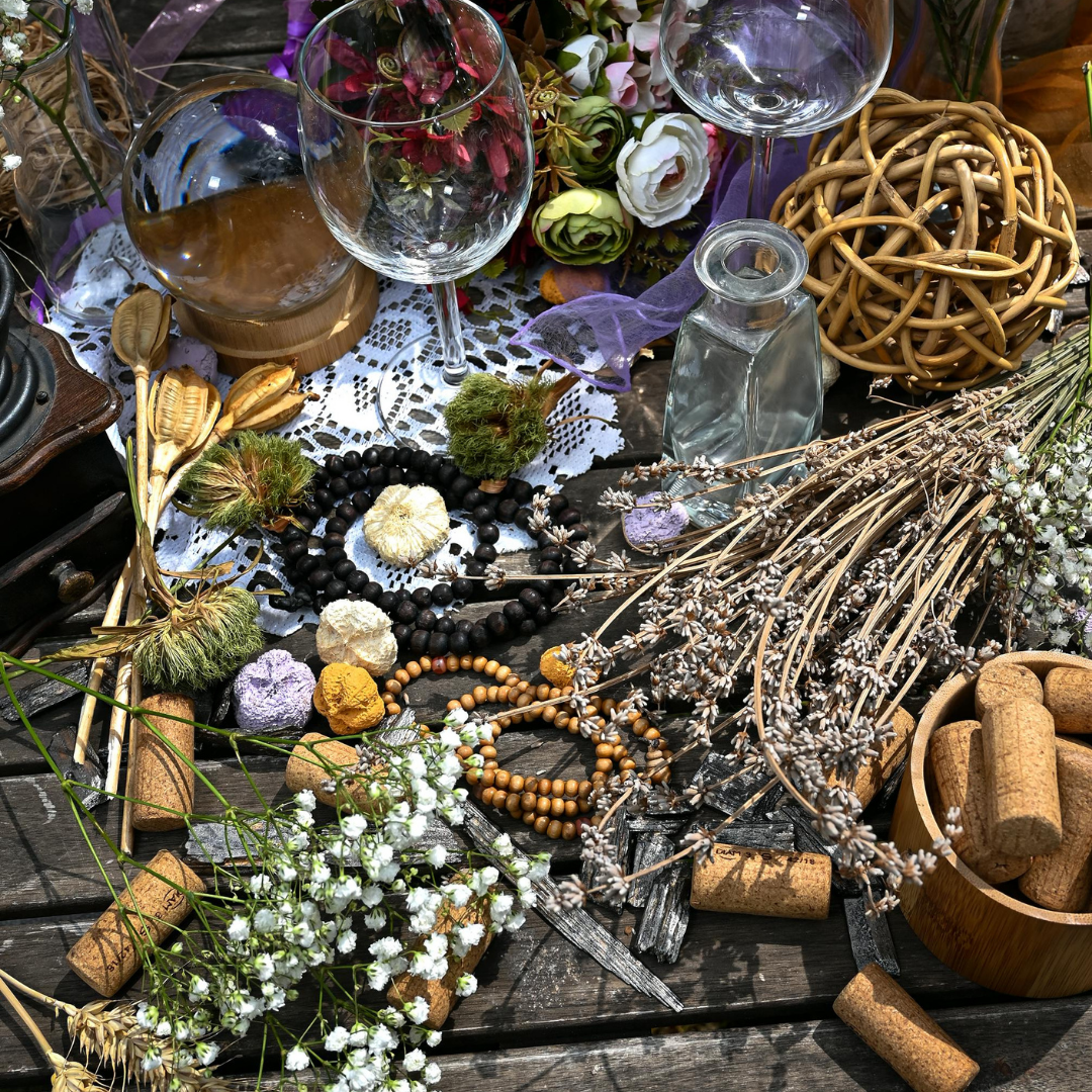 Arrangement of dried herbs, flowers, and natural objects on a table representing seasonal abundance and early summer growth