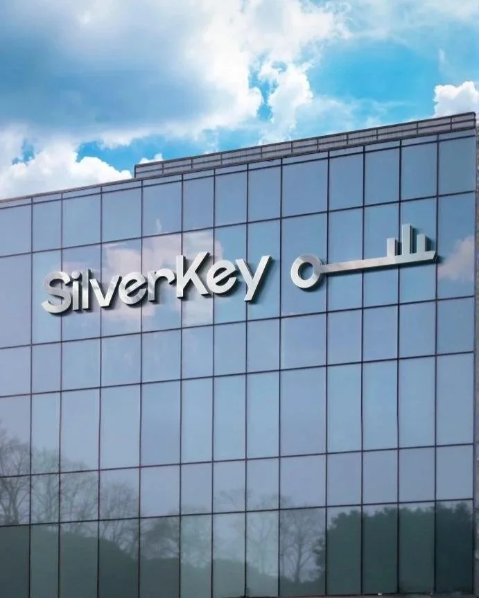 The exterior of a glass building with the company name 'SilverKey' and a key logo on the facade.
