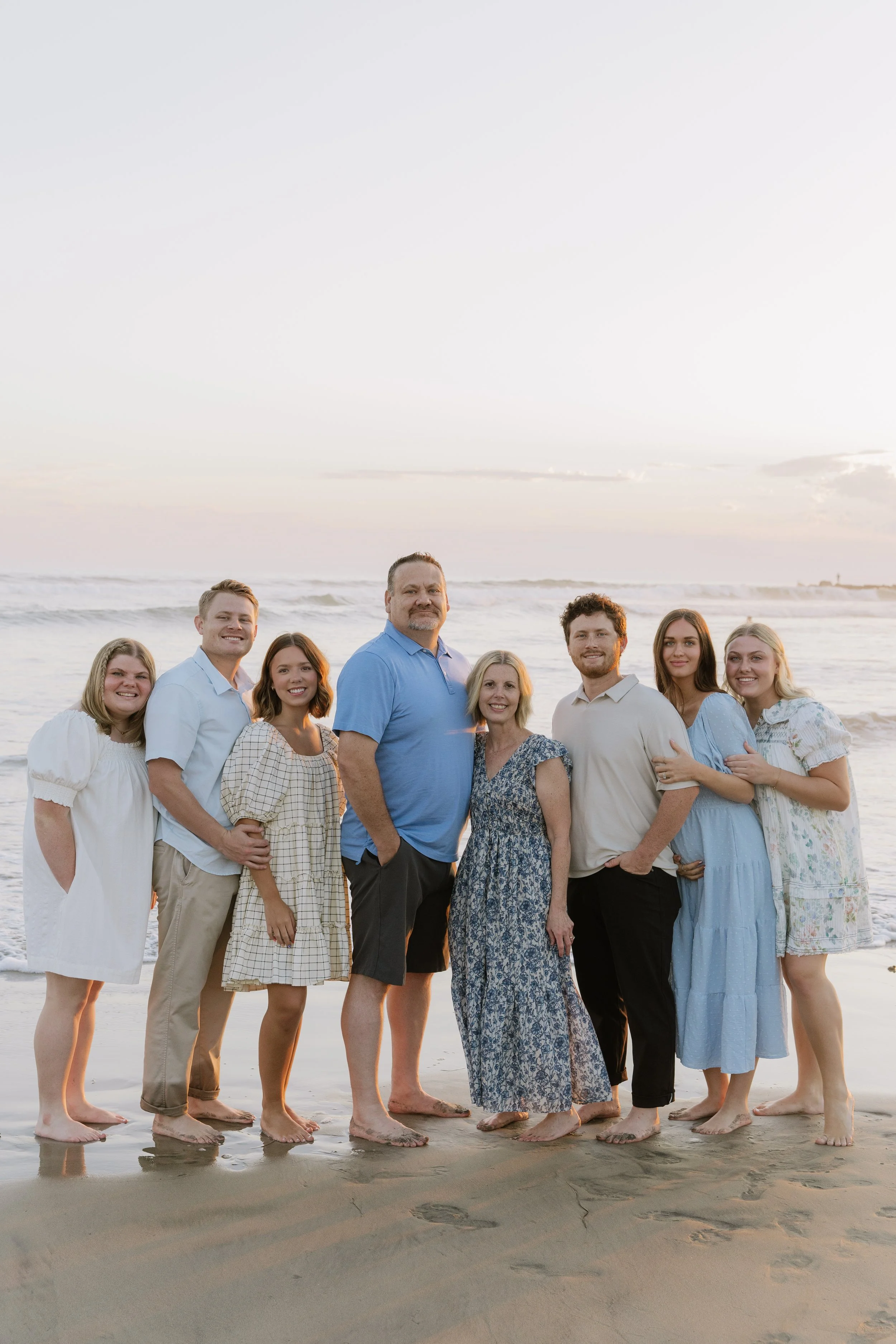 The Porter Family of Western Pine Development standing on the beach at sunset, smiling, with the ocean in the background.
