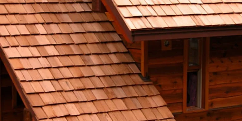 Close-up of a wooden house roof and part of a wooden wall with a window.