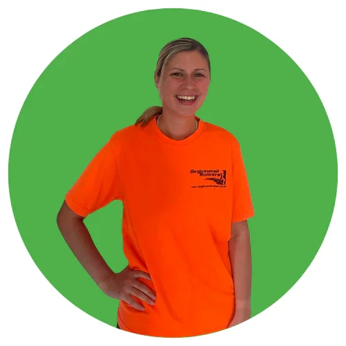 A smiling woman wearing an orange t-shirt with the logo 'Beginners Runner' standing against a green circular background.