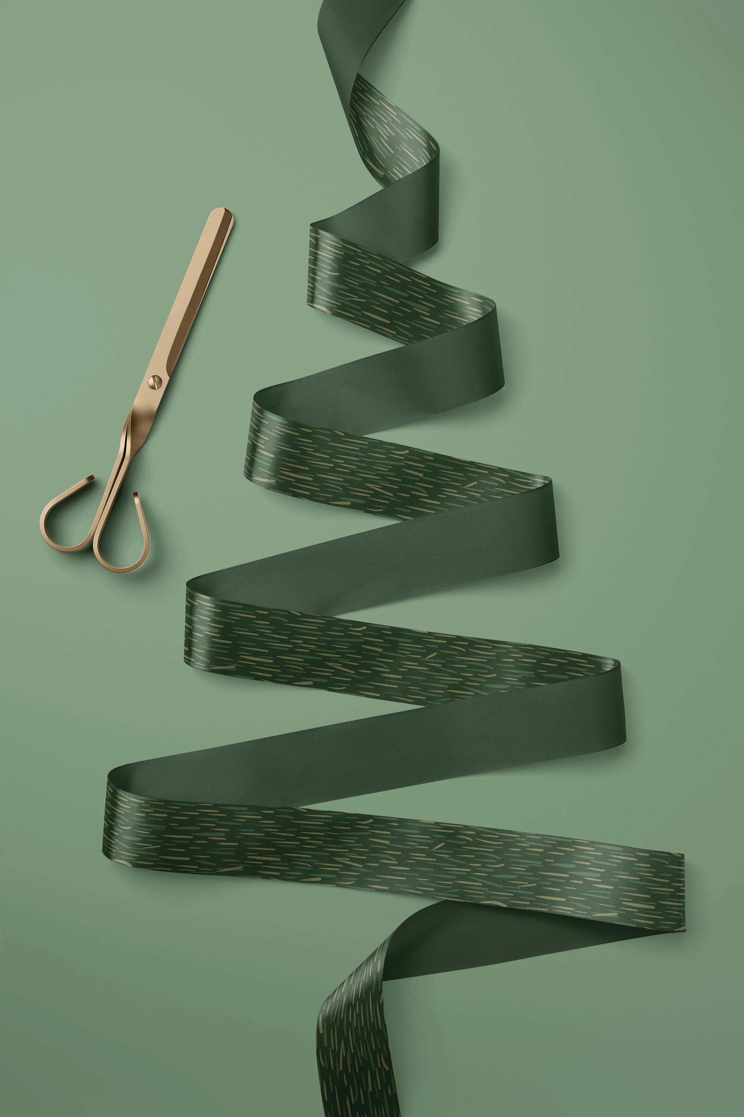 Deep green ribbon printed with a subtle textured stripe mimicking pine needles, arranged in a flowing Christmas tree-shaped spiral beside a pair of gold ribbon scissors.