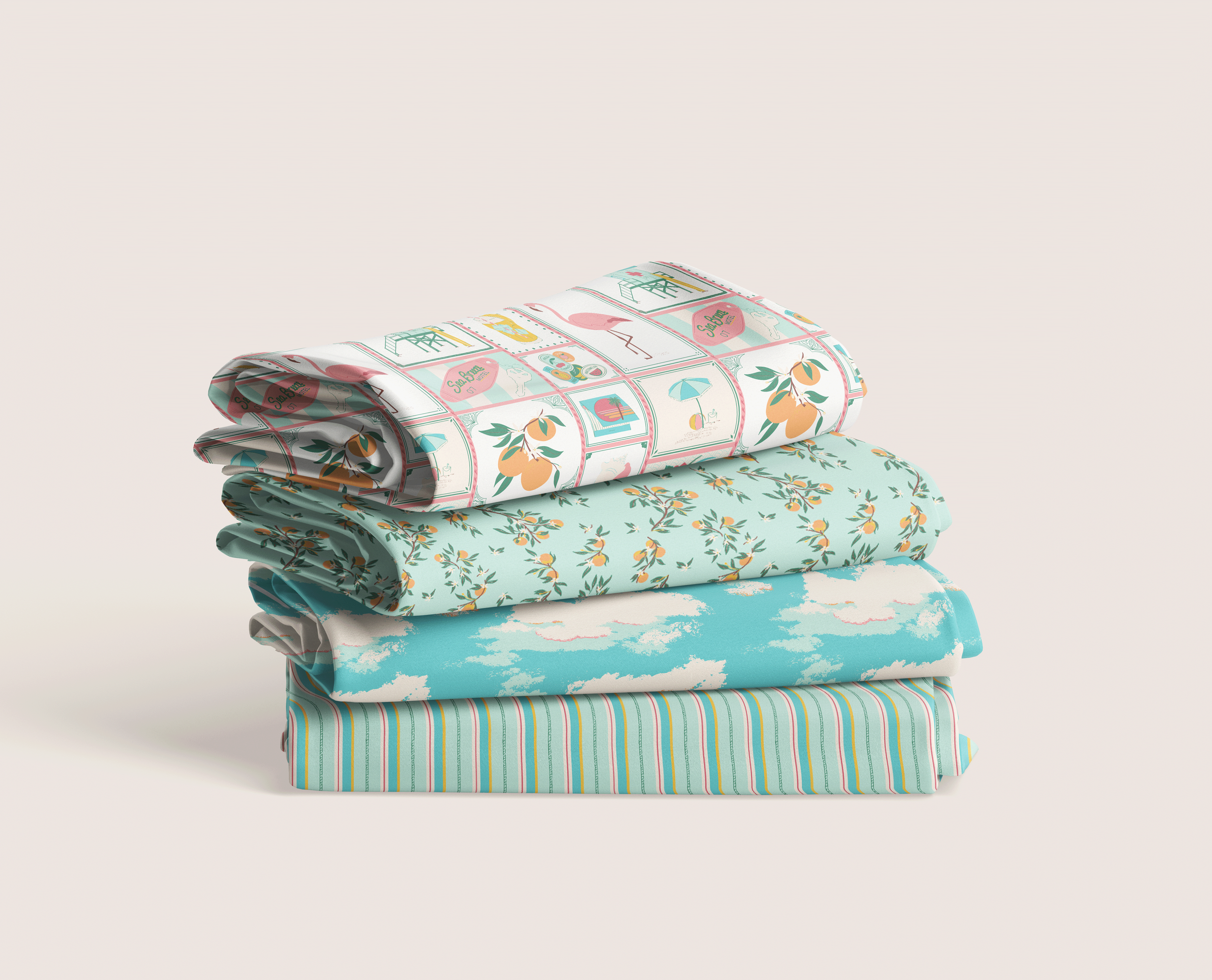 Stack of folded fabrics featuring coordinating beach-inspired surface patterns in soft aqua, coral, and citrus tones on a neutral studio background.