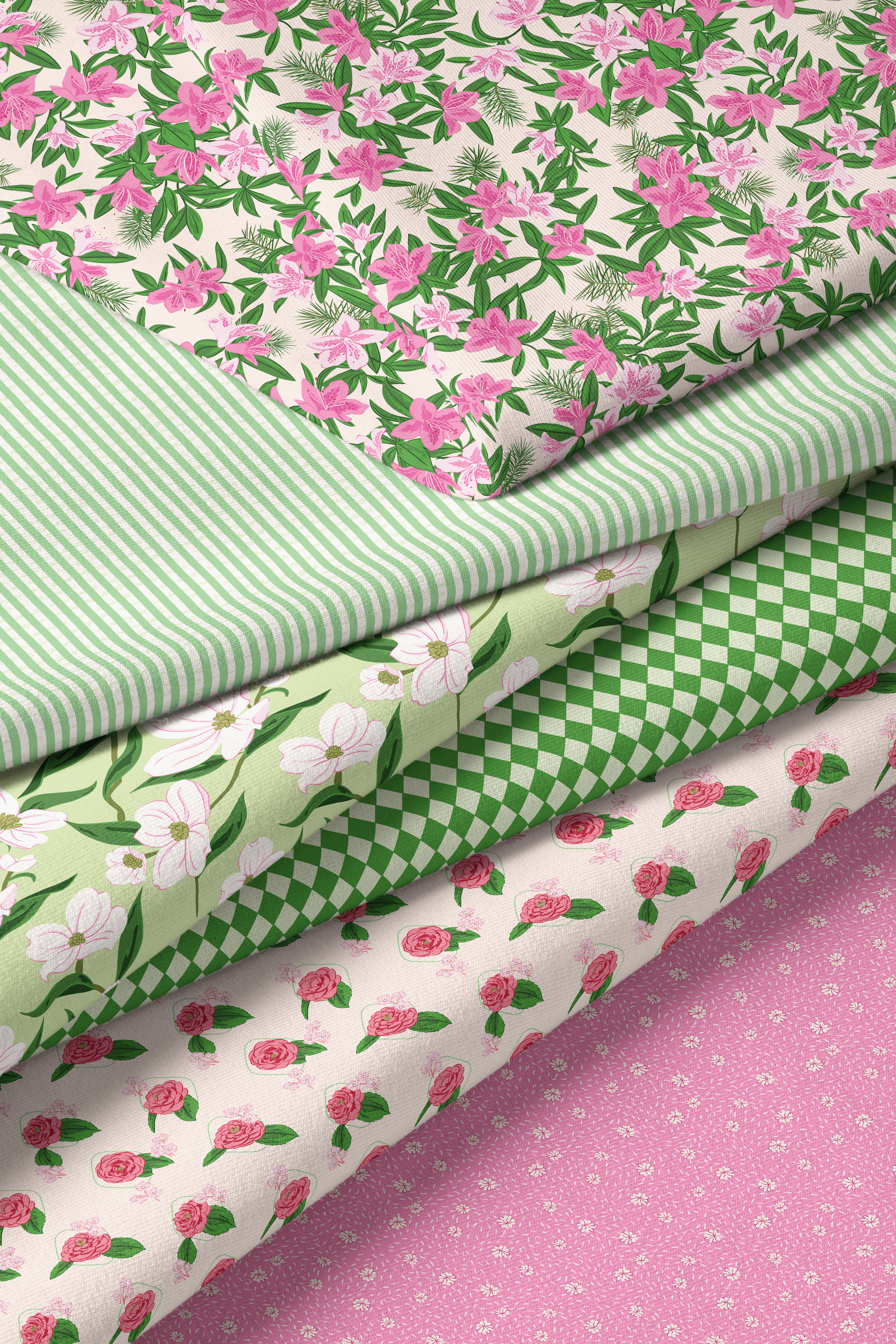 Stack of folded fabrics from the Lawn League collection featuring pink floral prints, green stripes, geometric diamonds, and coordinating spring patterns in a pink and green palette.