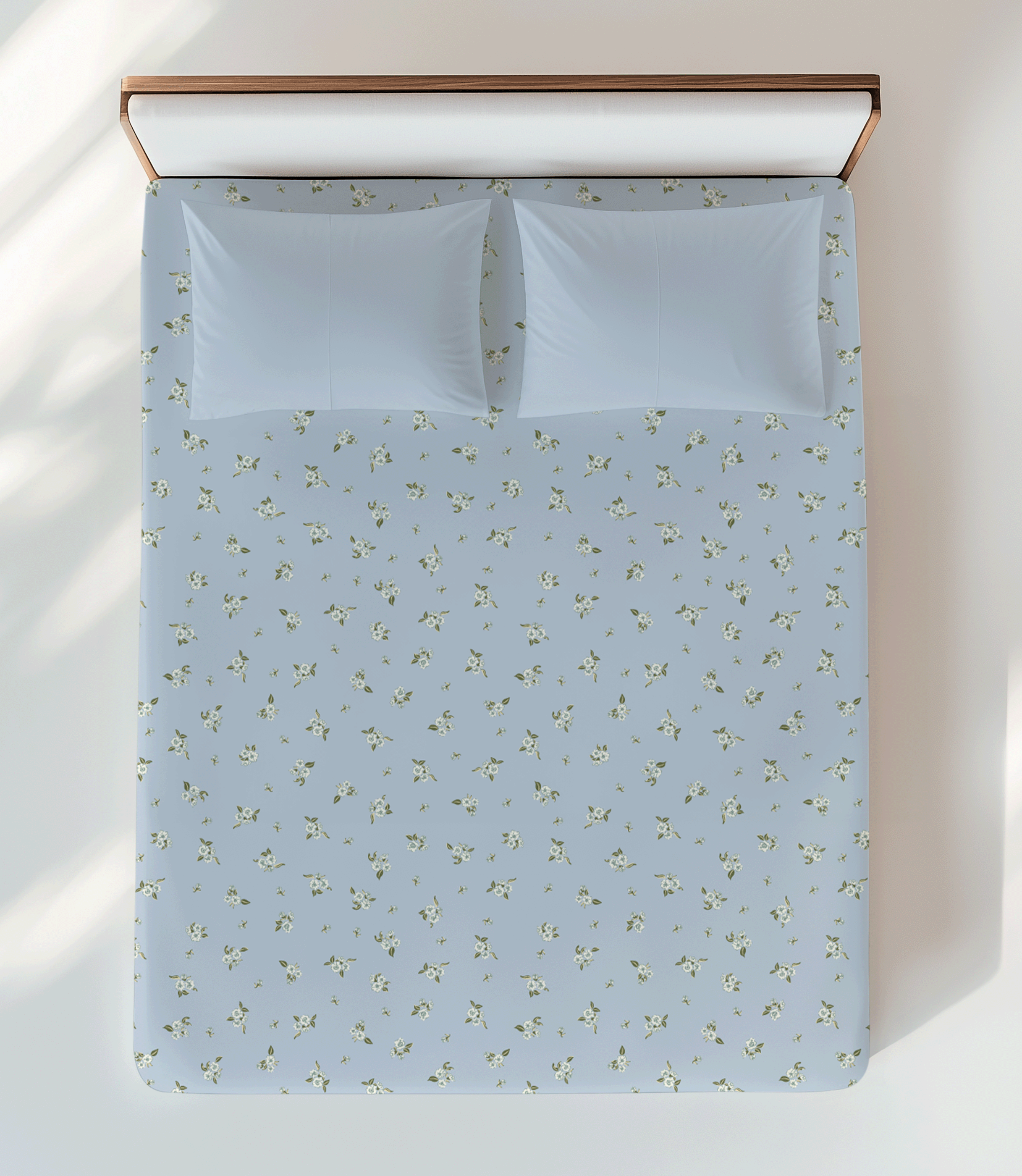 Surface pattern design featuring scattered small florals, inspired by garden linens laid out on the lawn, displayed on bed sheets.