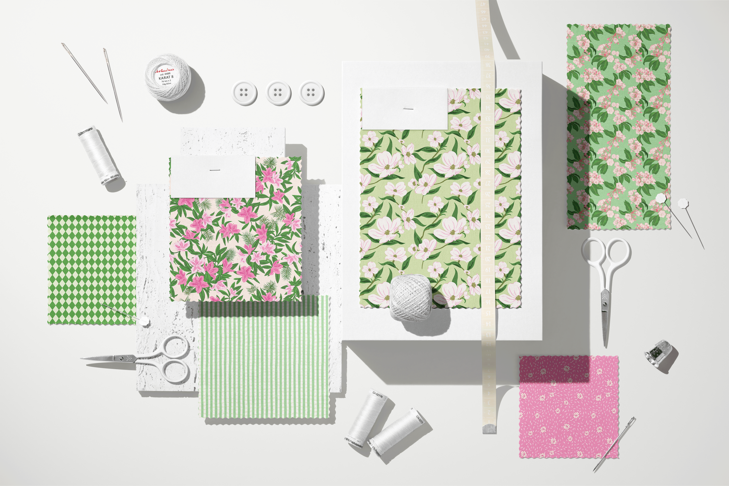 Coordinating Lawn League fabric swatches arranged with sewing tools, buttons, thread, and measuring tape, featuring floral, striped, geometric, and blender patterns.