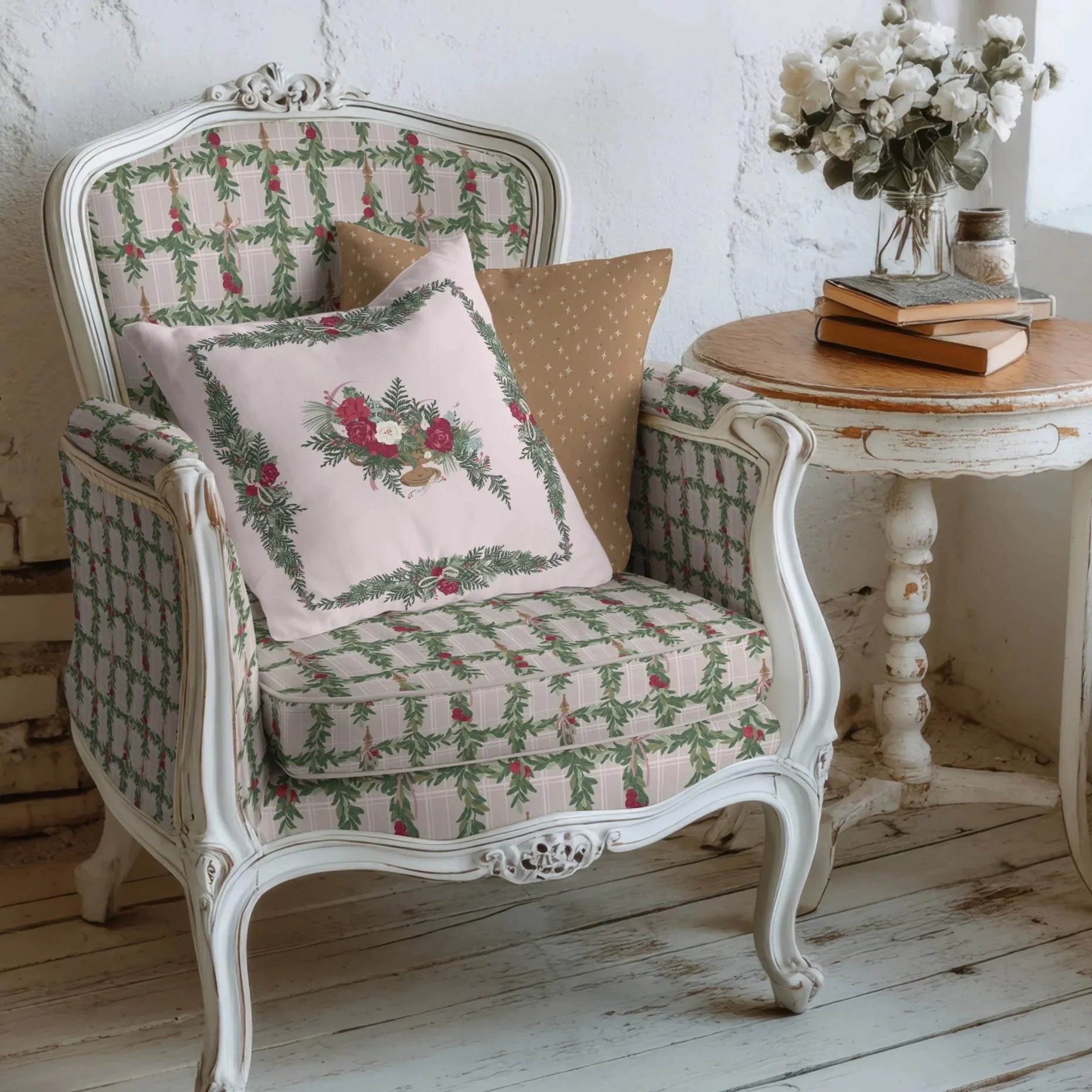 Vintage upholstered armchair covered in a soft blush plaid with hanging evergreen garlands, styled with a decorative pillow featuring a lush winter floral arrangement and a coordinating gold star print pillow.