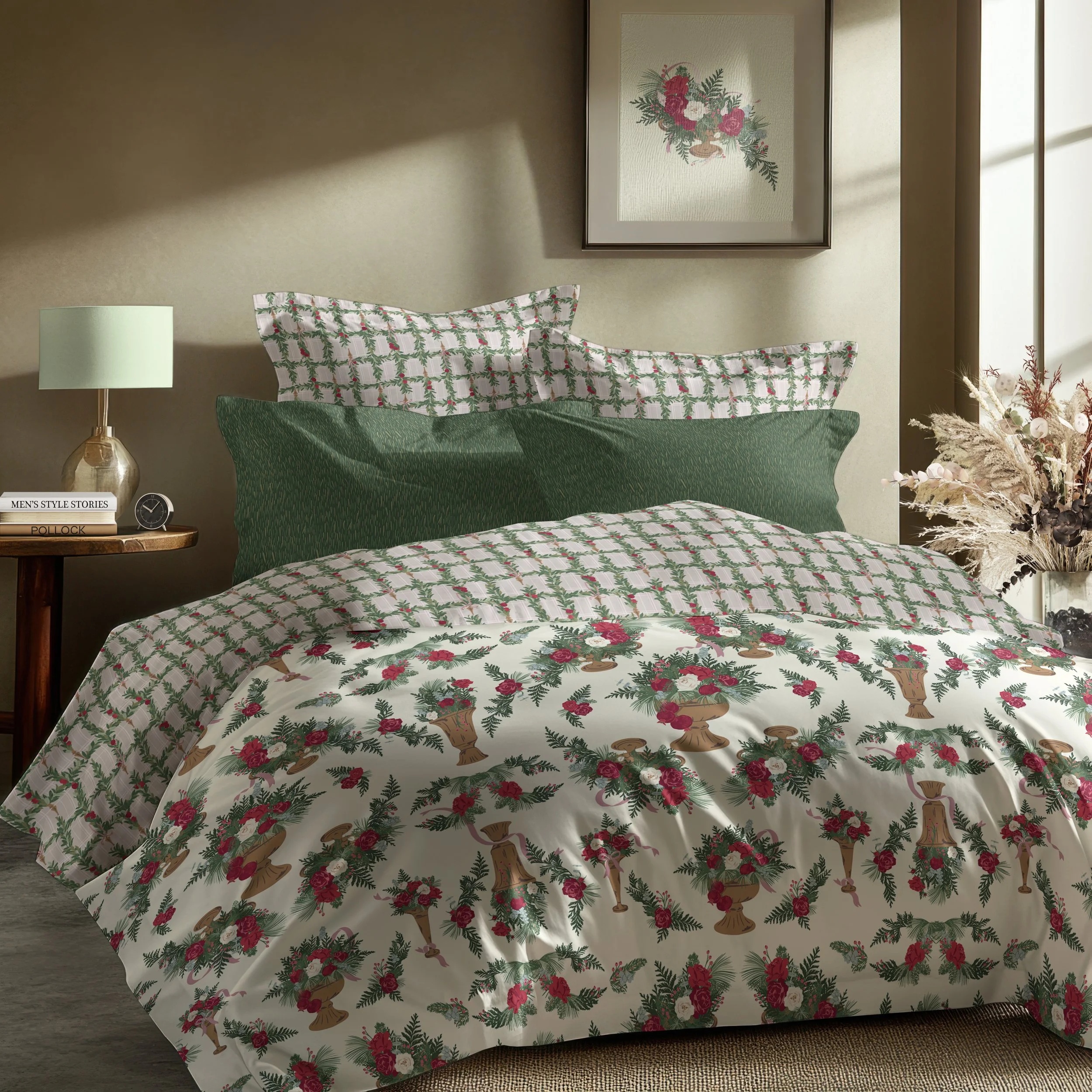 Coordinated bedding featuring a duvet printed with elegant winter floral arrangements in antique pedestal vessels, paired with blush plaid pillowcases accented by hanging evergreen garlands and solid deep green accent pillows.