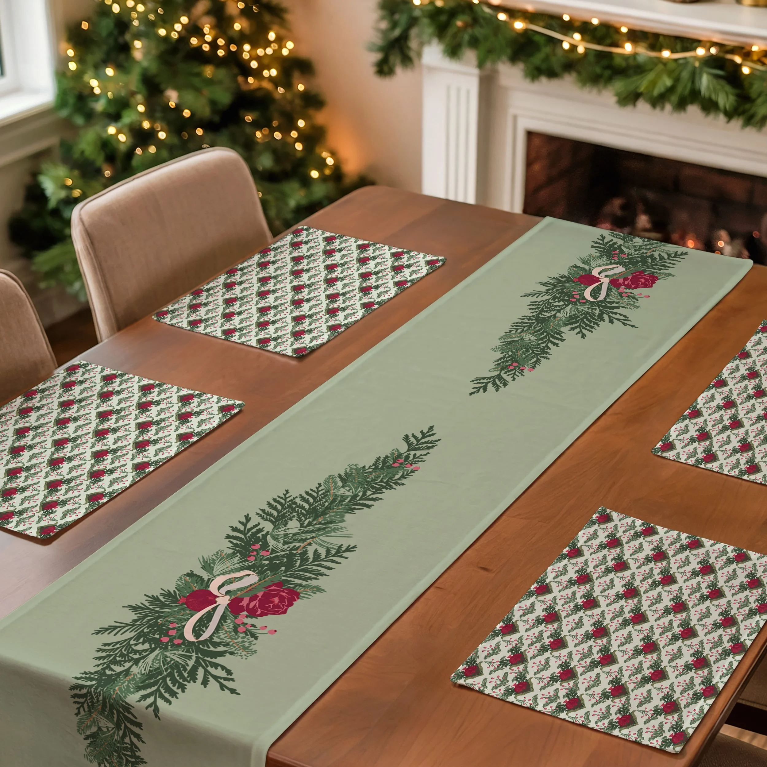 Holiday dining table styled with a sage green table runner featuring evergreen garland arrangements and coordinating placemats printed with stylized pomegranates and winter greenery.