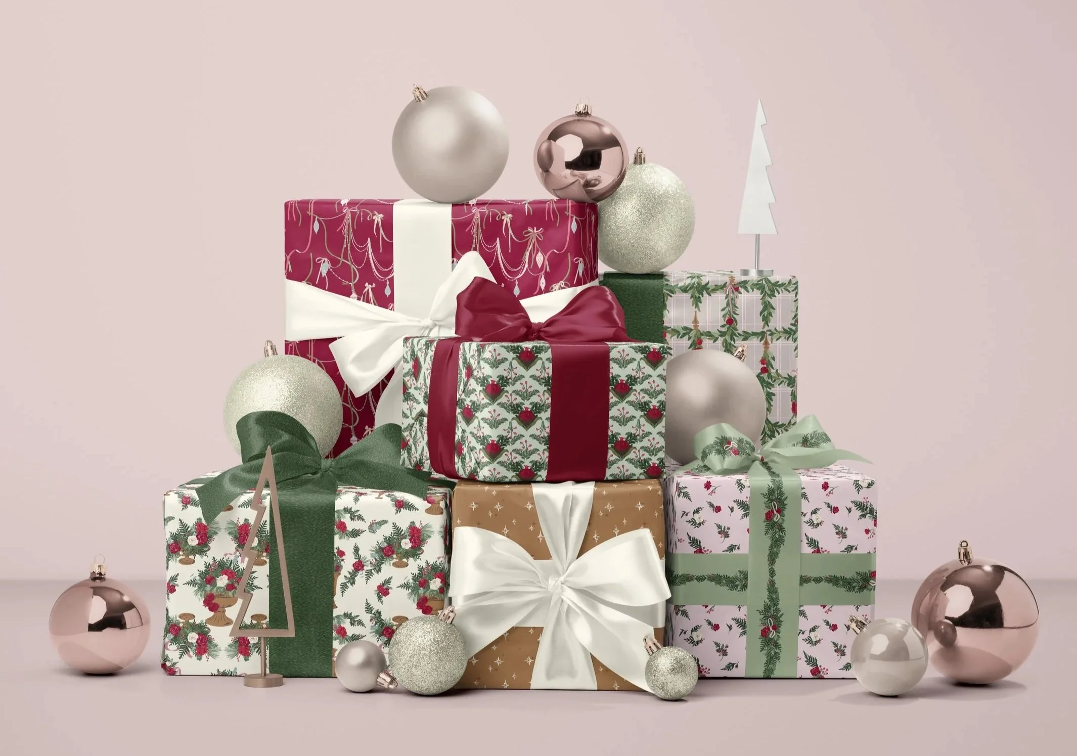 Stack of wrapped Christmas presents featuring coordinating gift wrap with elegant winter florals, ribbon garlands, hanging evergreen garlands, stylized pomegranates, and scattered winter florals, finished with satin ribbons and ornaments.