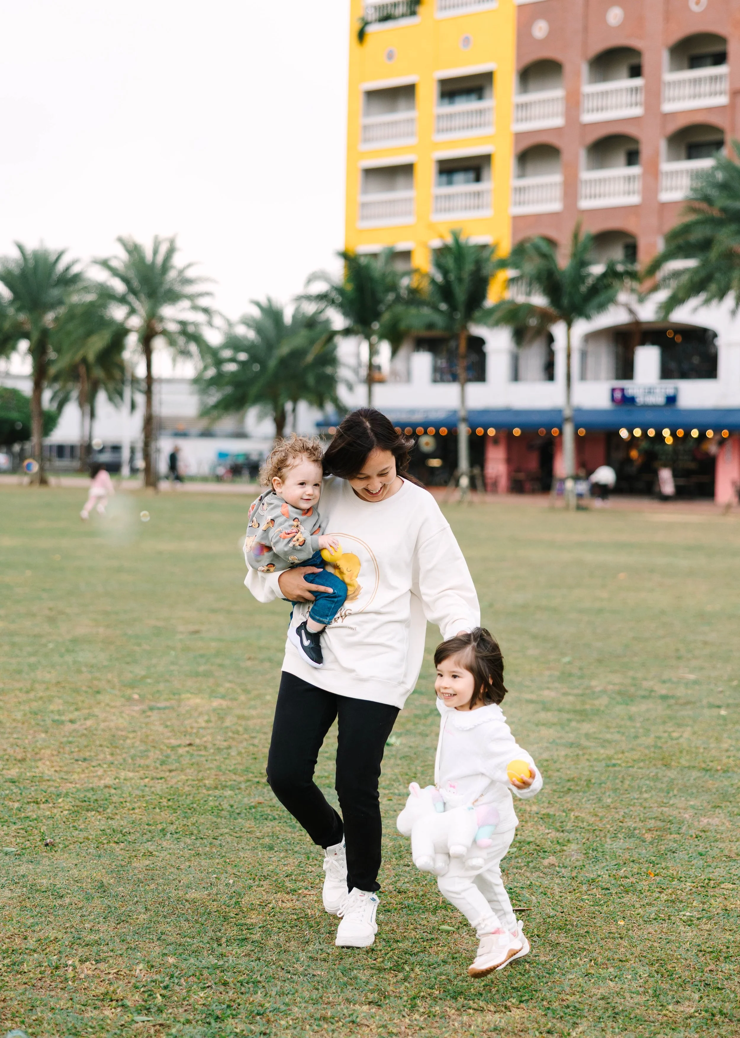two young children playing with a caregiver women at daycare