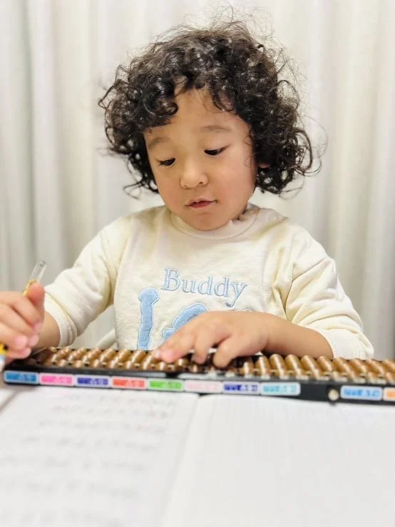 Child taking a abacus class at a nursery.