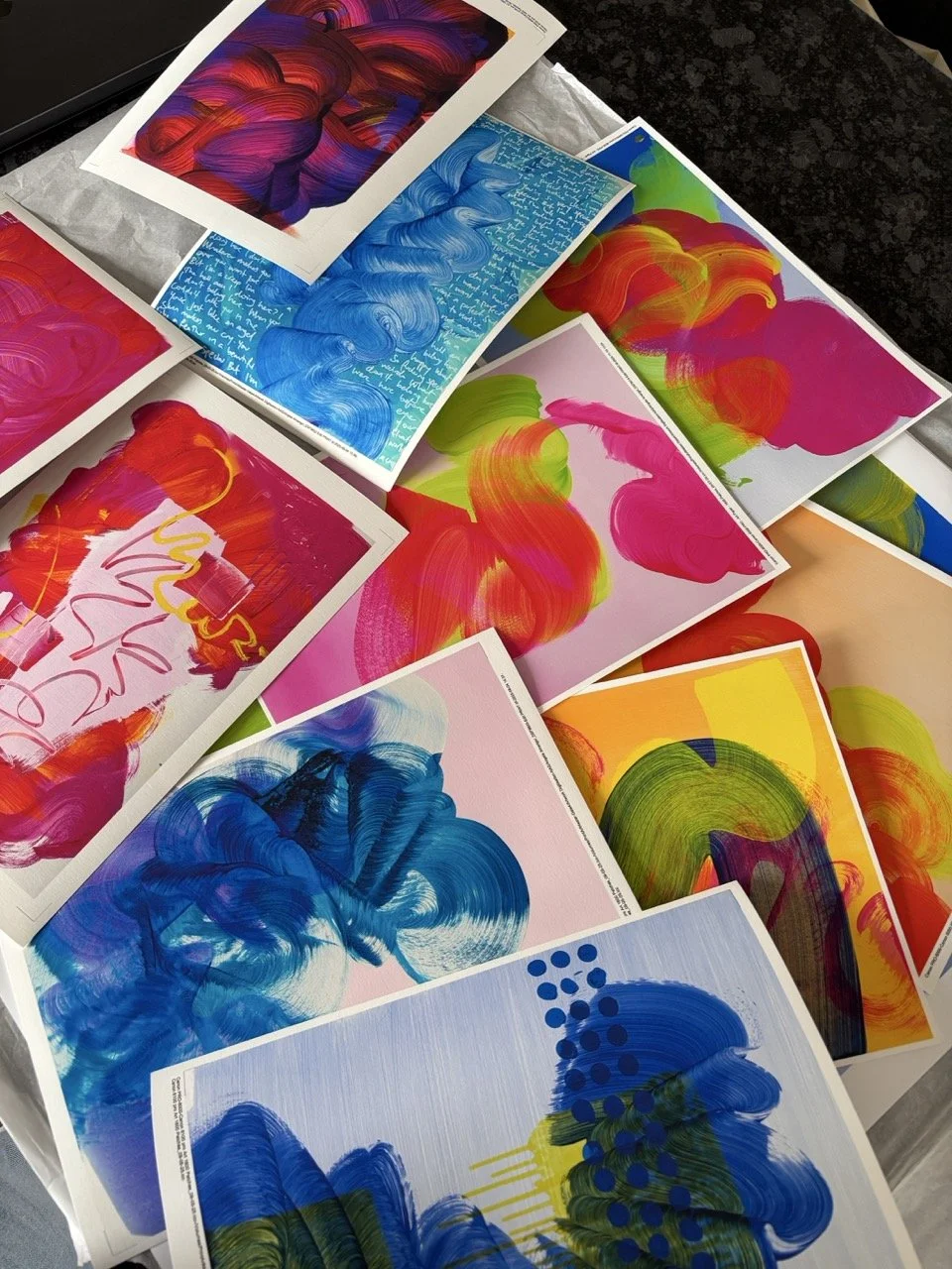 A collection of colorfully abstract artistic prints featuring bold brushstrokes, swirls, and patterns in various bright colors like blue, pink, red, green, yellow, and orange.