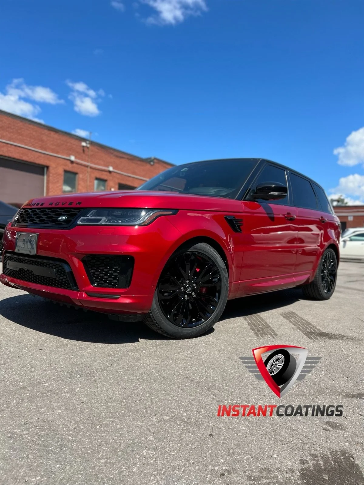 Red Range Rover SUV parked on asphalt in front of brick building under blue sky. Logo of Instant Coatings in foreground.