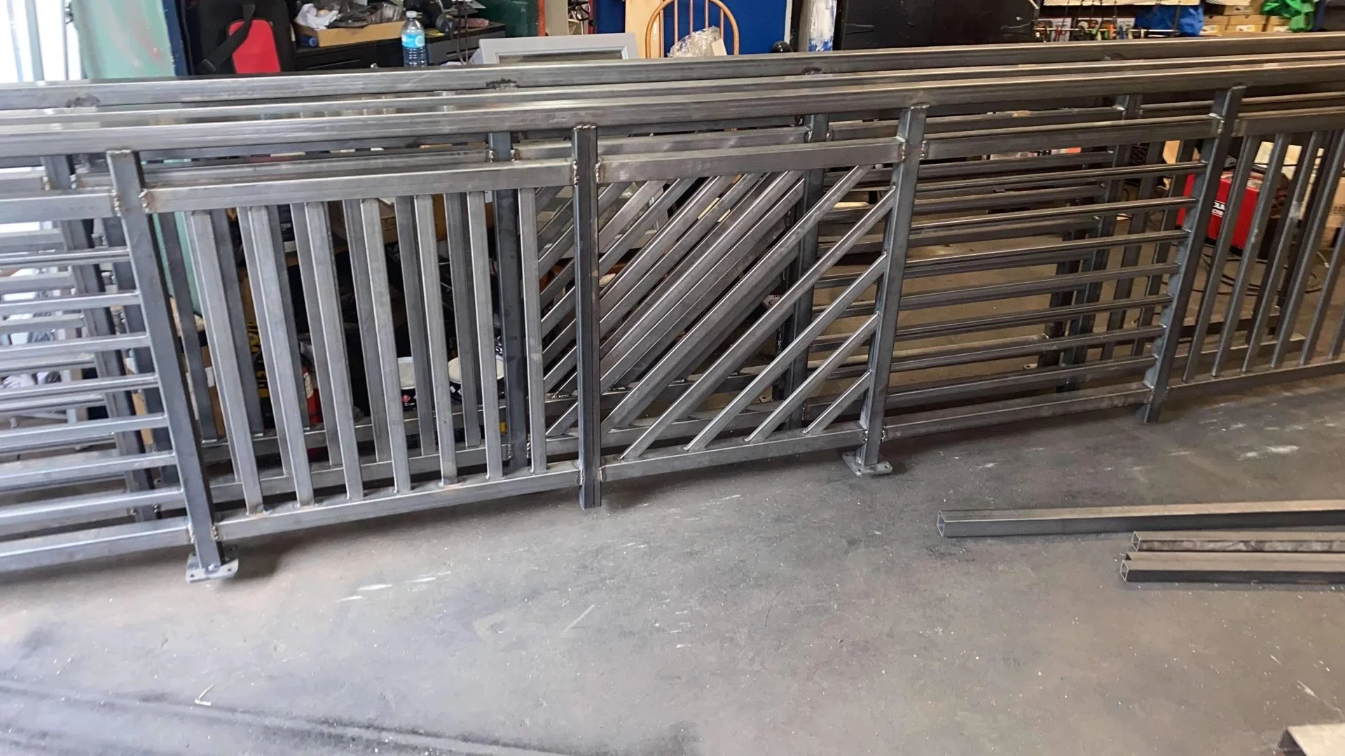 A row of metal barriers or gates stacked together in a workshop or storage area.