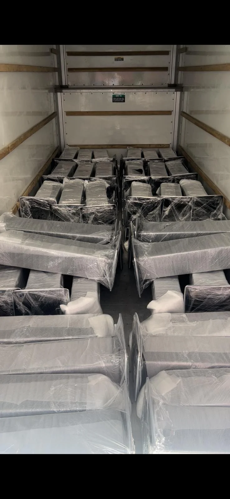 Empty truck with stacked wrapped boxes inside.