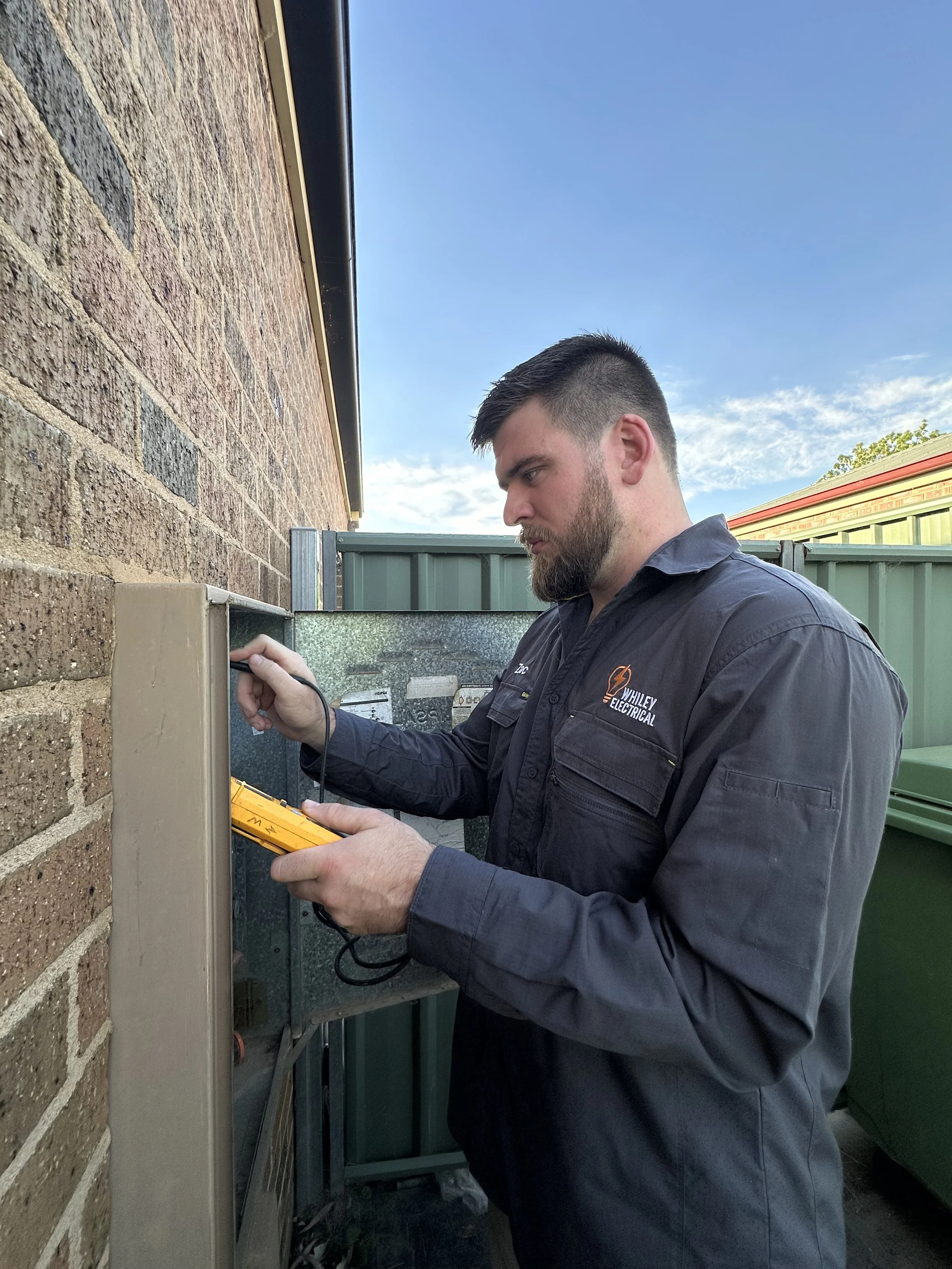 Man with beard working on a switchboard outside - Whiley Electrical - Bendigo Electrician - Services