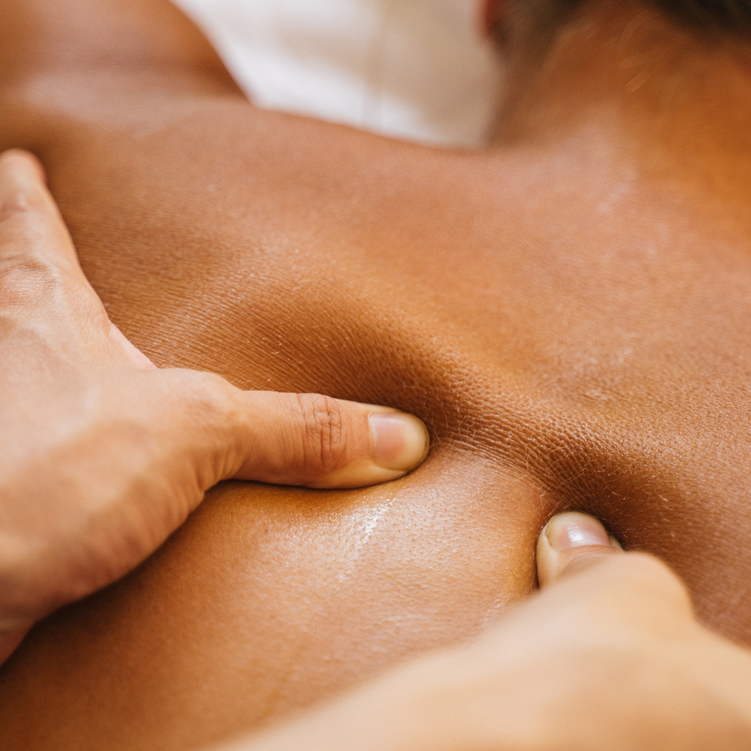 The Therapists hands are performing deep tissue massage on a client's back