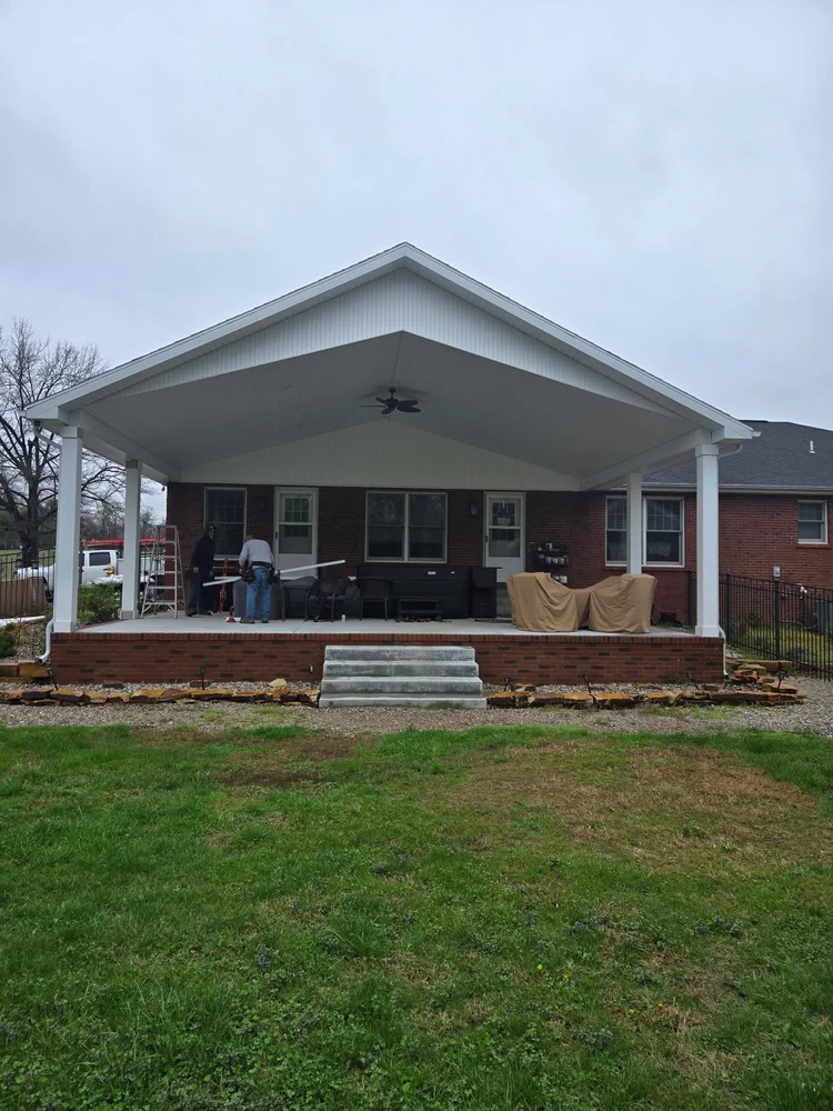 Covered back patio with gable roof and white columns built by Tenbarge Exteriors