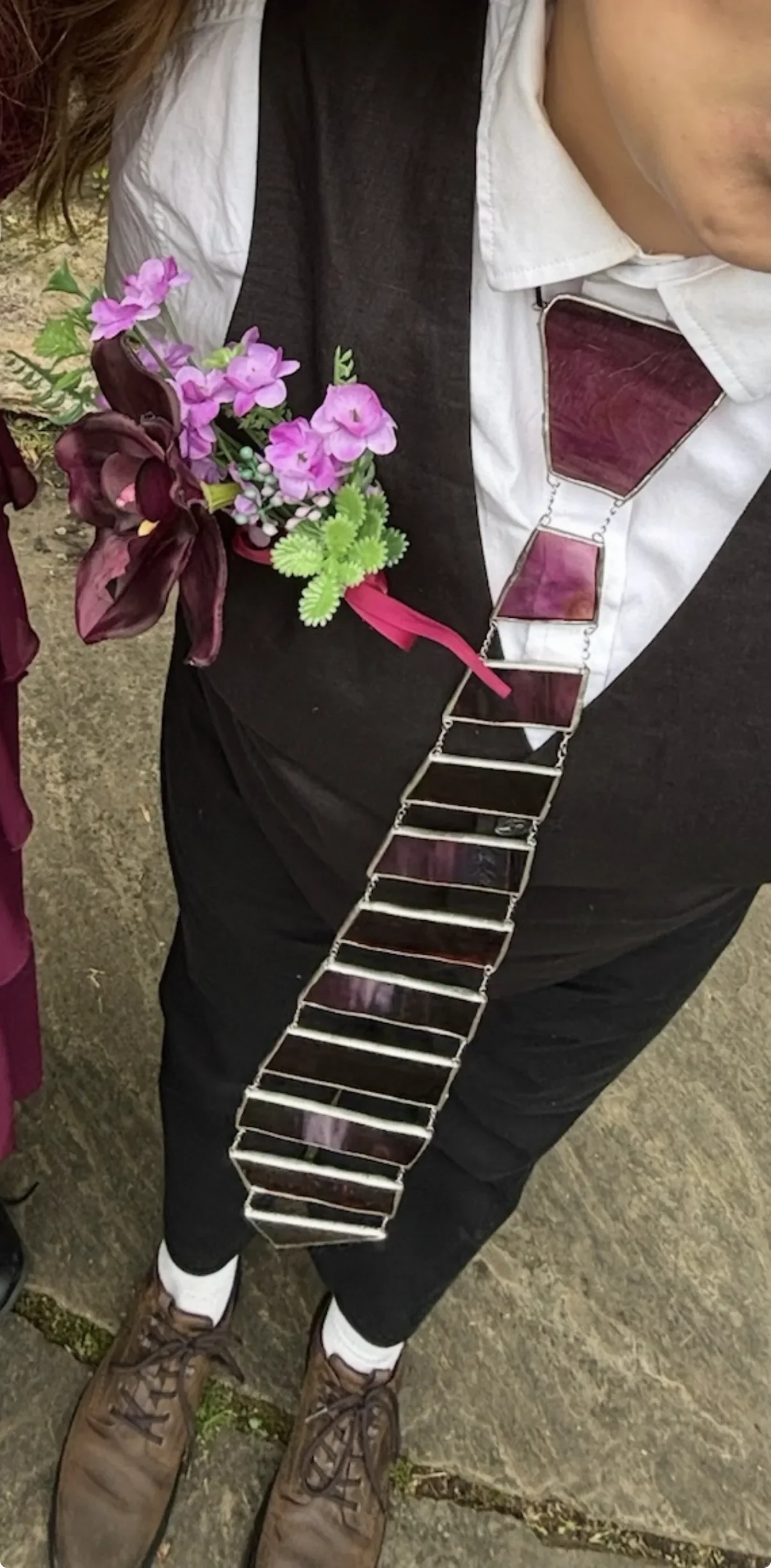 Maroon glass tie worn by a person in a suit