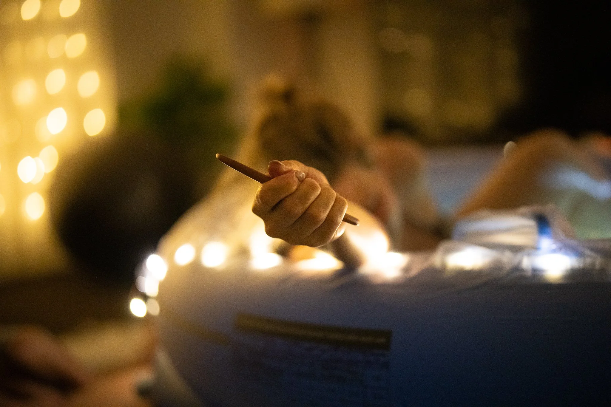 Close-up of a homebirth setting with a women holding out an incense stick in warm lighting.