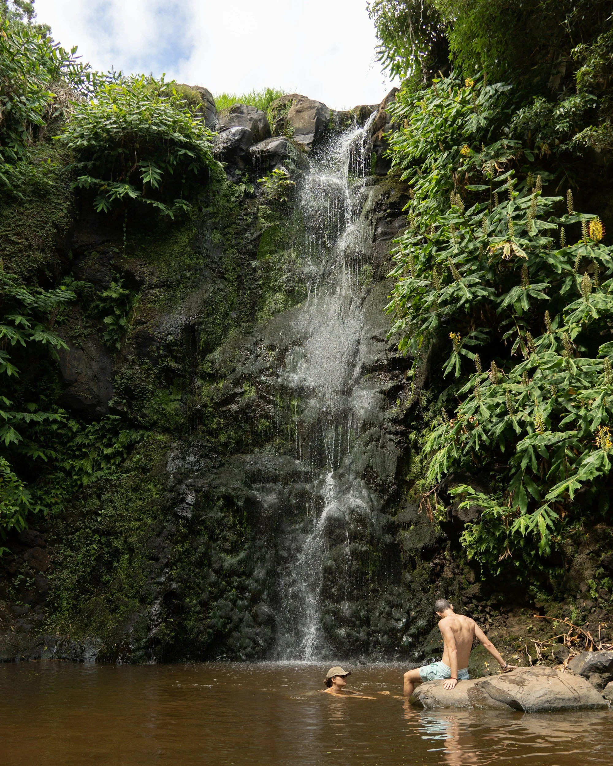 couple sitting by waterfall