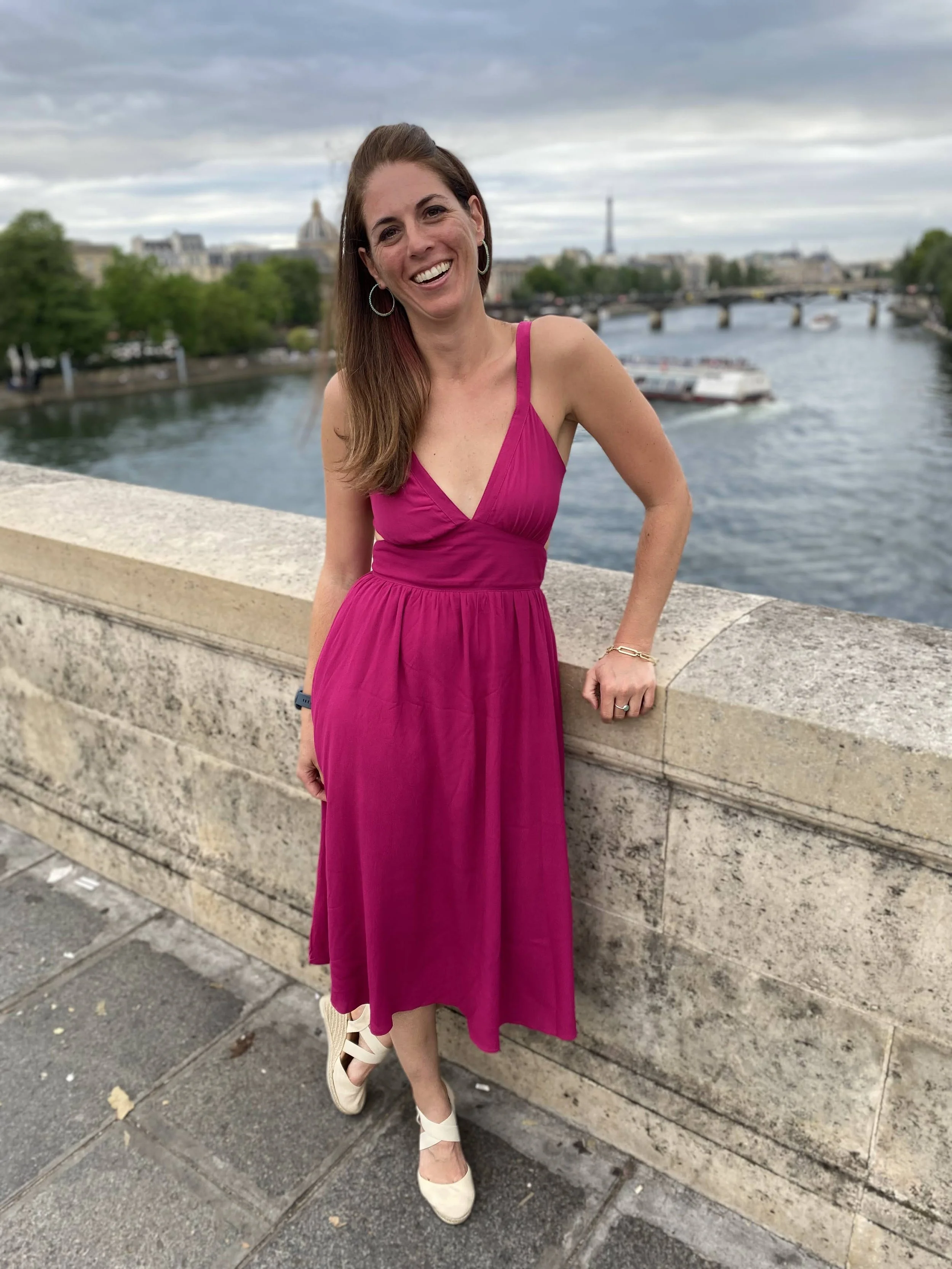 women in pink dress on bridge in Paris
