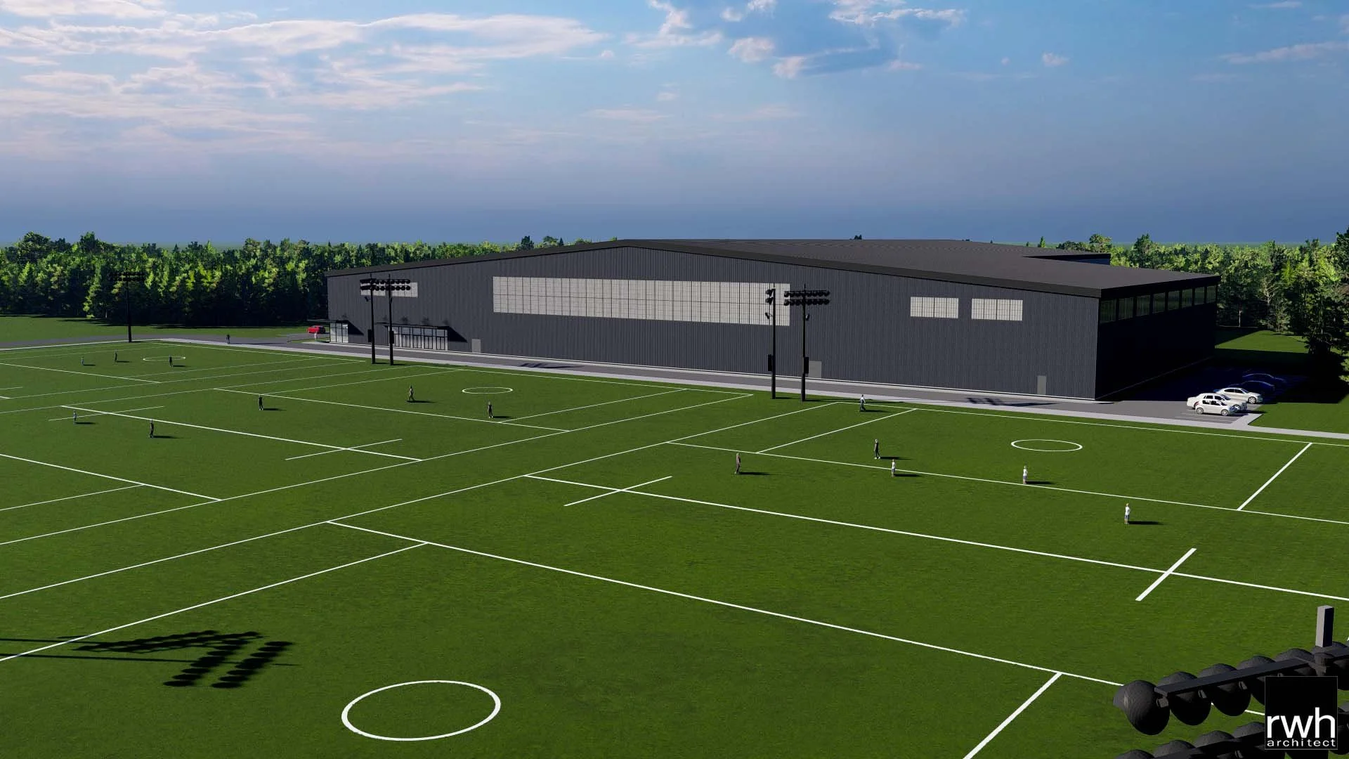 A modern sports facility with a large, black building and multiple soccer fields with white lines, situated in a green landscape under a partly cloudy sky.