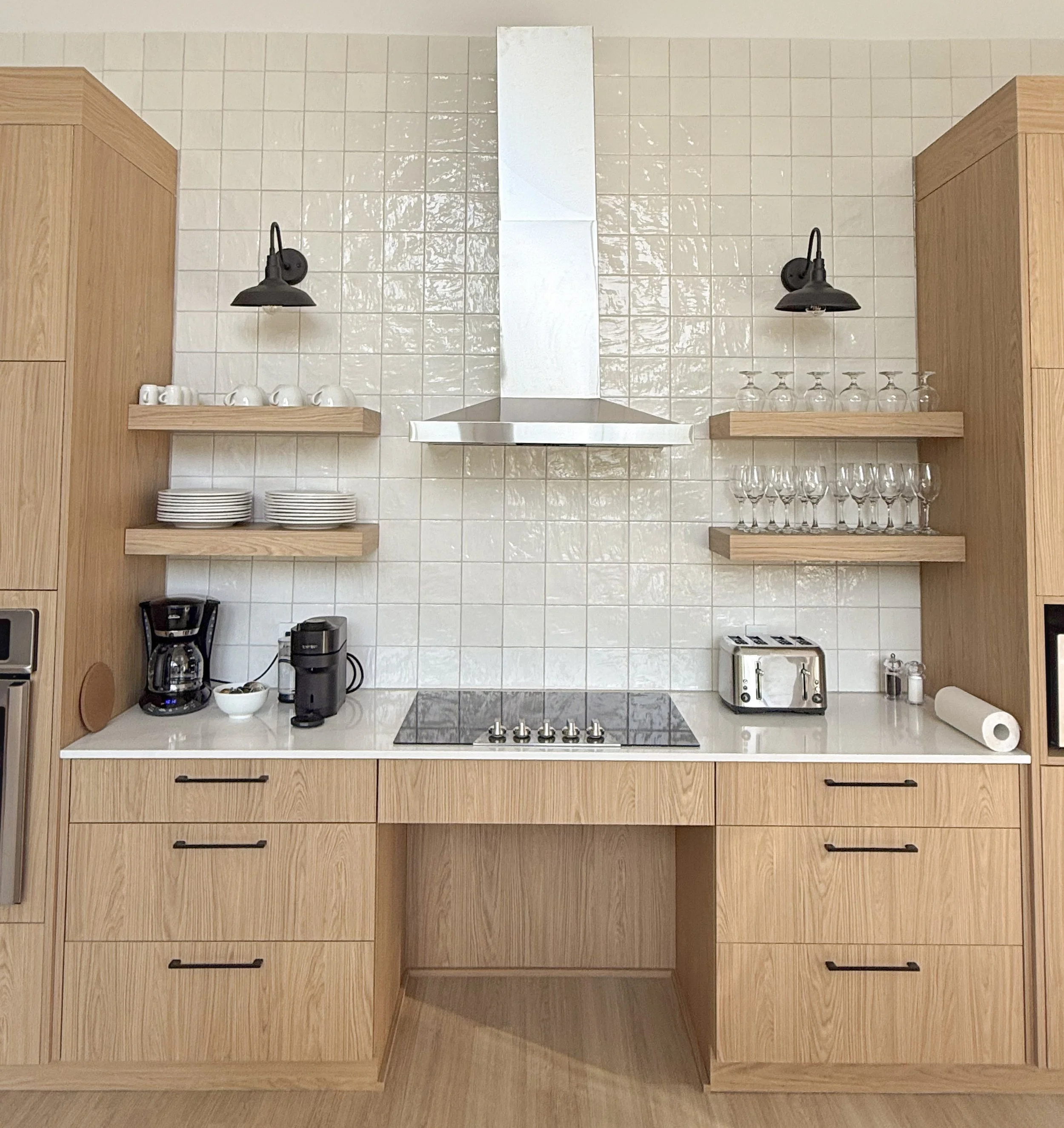 Cuisine moderne avec armoires en bois, étagères, tasses, verres, appareils électroménagers et papier essuie-tout.