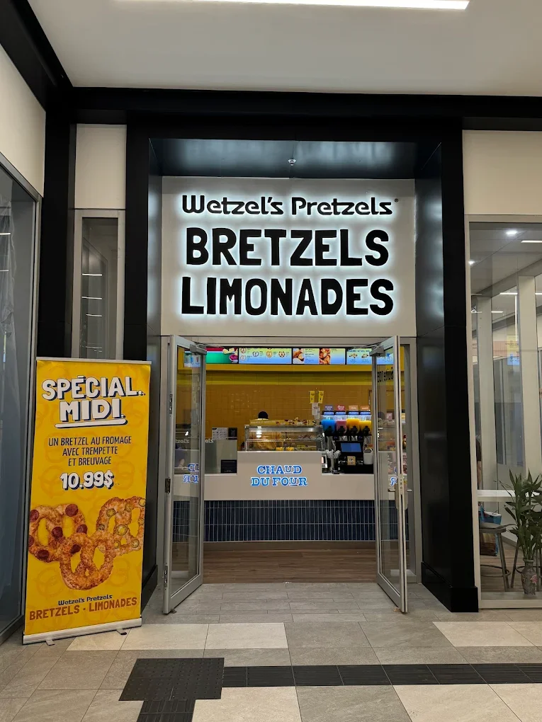 Entrée d'un stand de restauration vendant des pretzels, des bretzels, des limonades et des produits chauds.