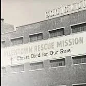 Building with a sign that reads 'Urban Rescue Mission - Christ Died for Our Sins'