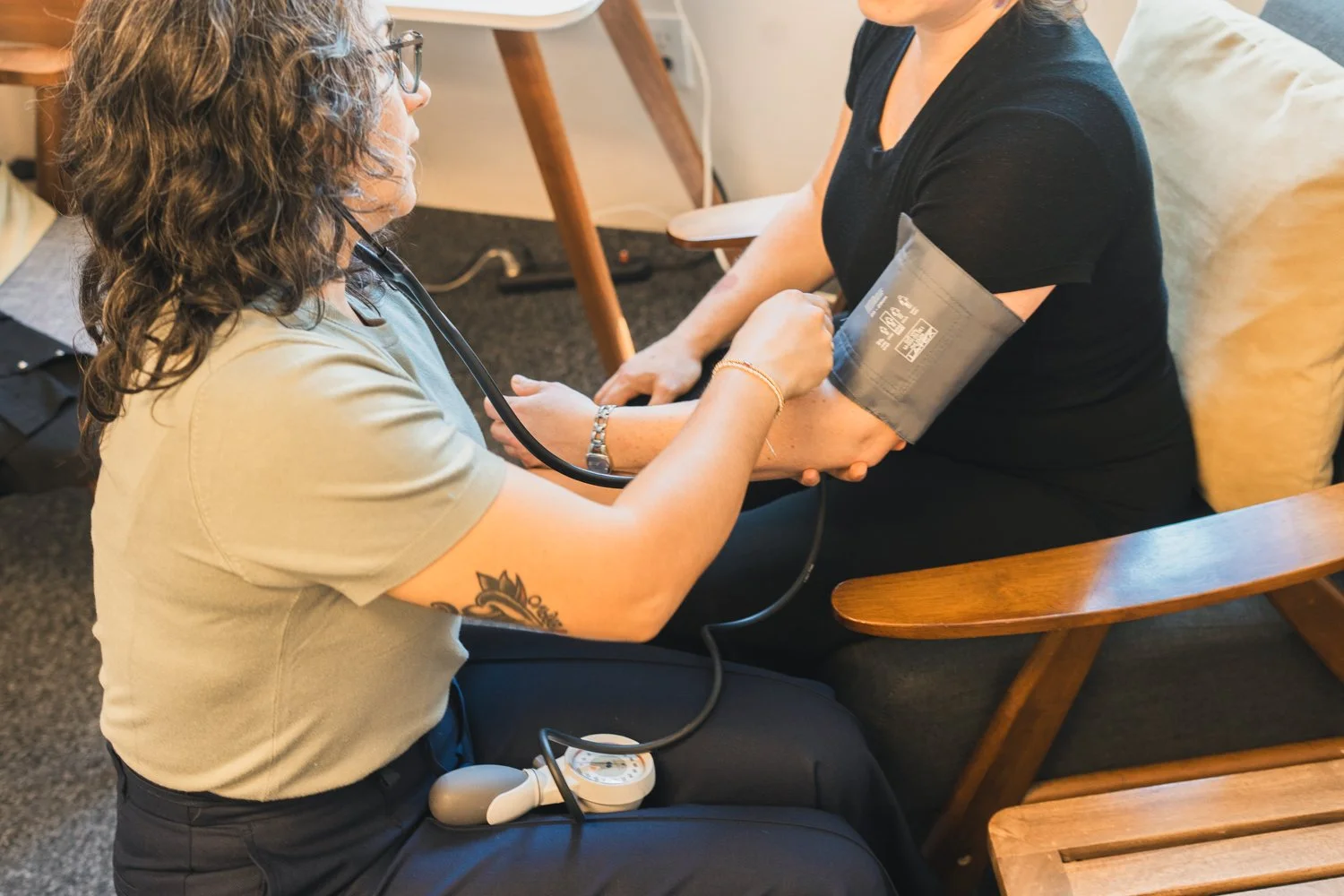 A healthcare professional measuring a woman's blood pressure using a sphygmomanometer.