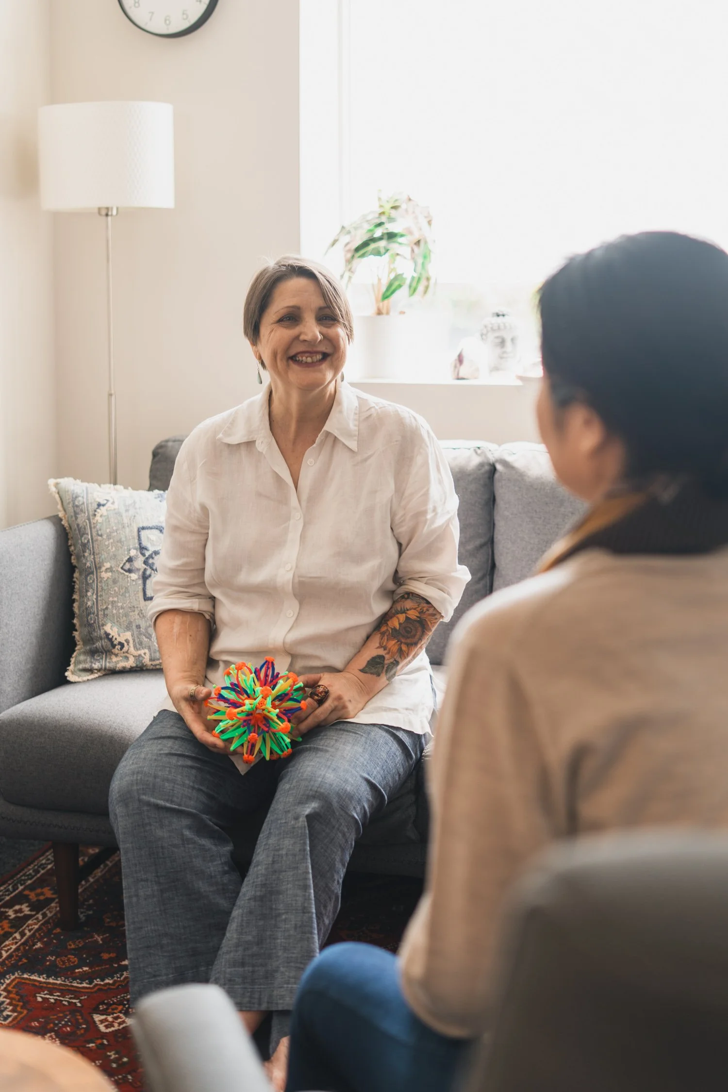 Two people sitting across from one another holding sensory objects.