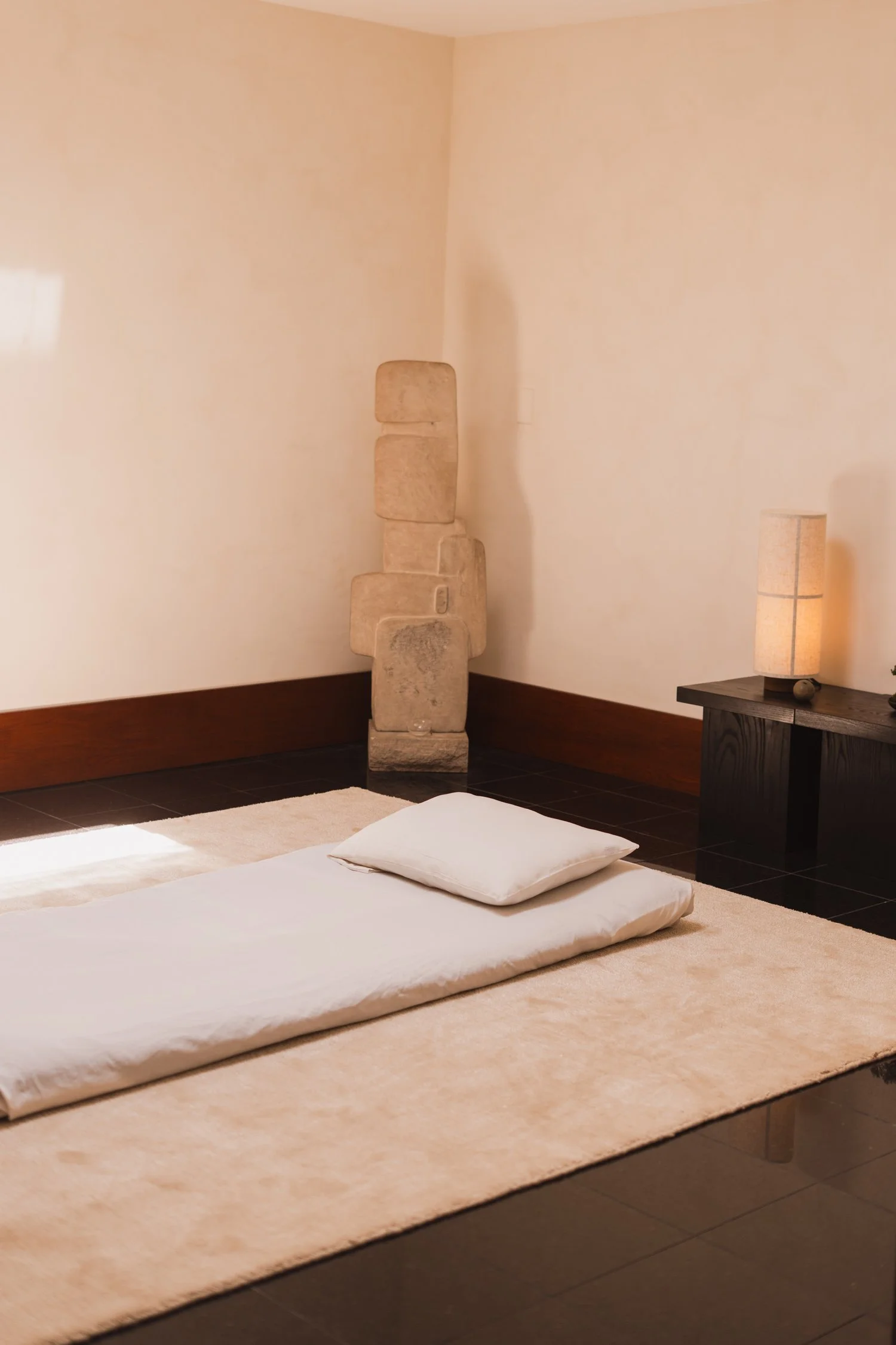 Shiatsu mat on a white carpet in a zen room.
