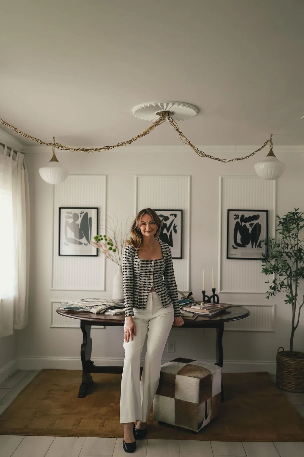 Catherine Porter standing in a thoughtfully designed dining room featuring modern luxury interior design, custom furnishings, and curated home styling.