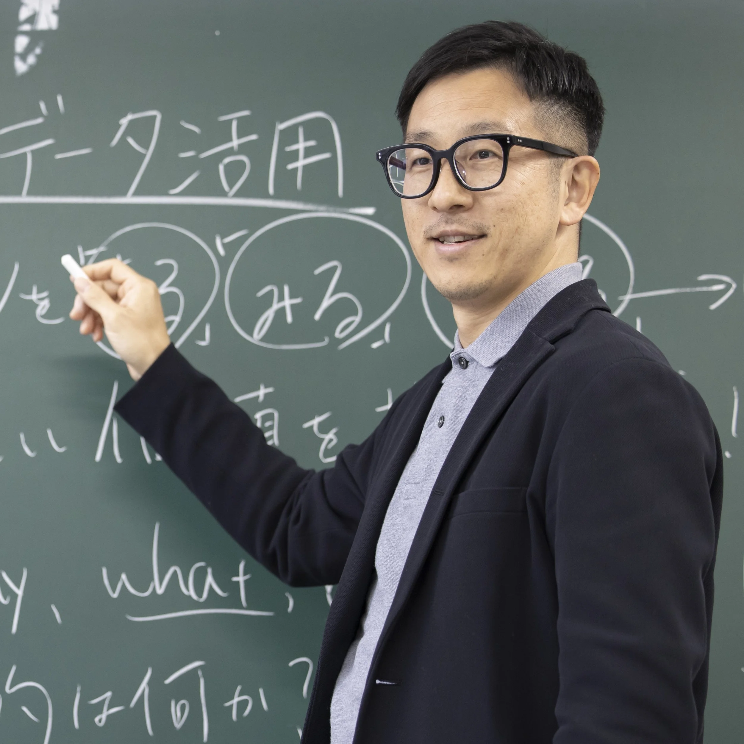 黒板に数学の式を手書きしている男性教授