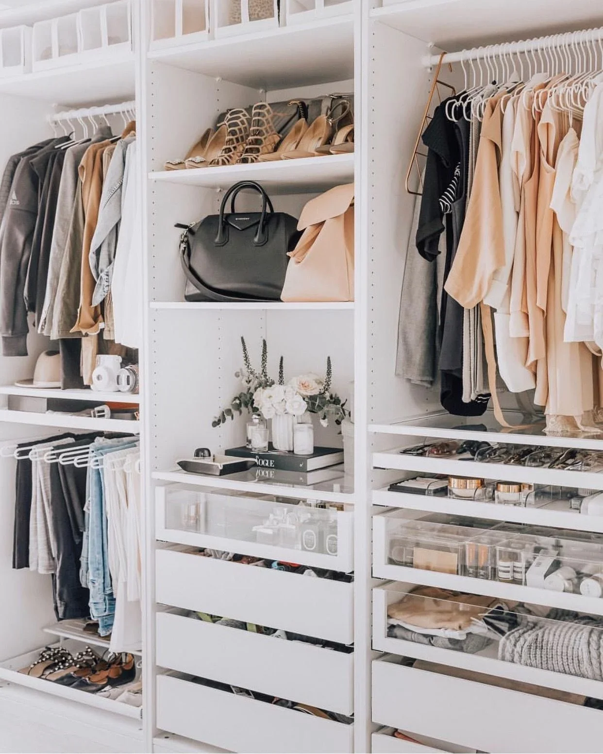 A well-organized walk-in closet featuring shelves filled with handbags, shoes, clothing, and accessories in neutral and pastel colors.