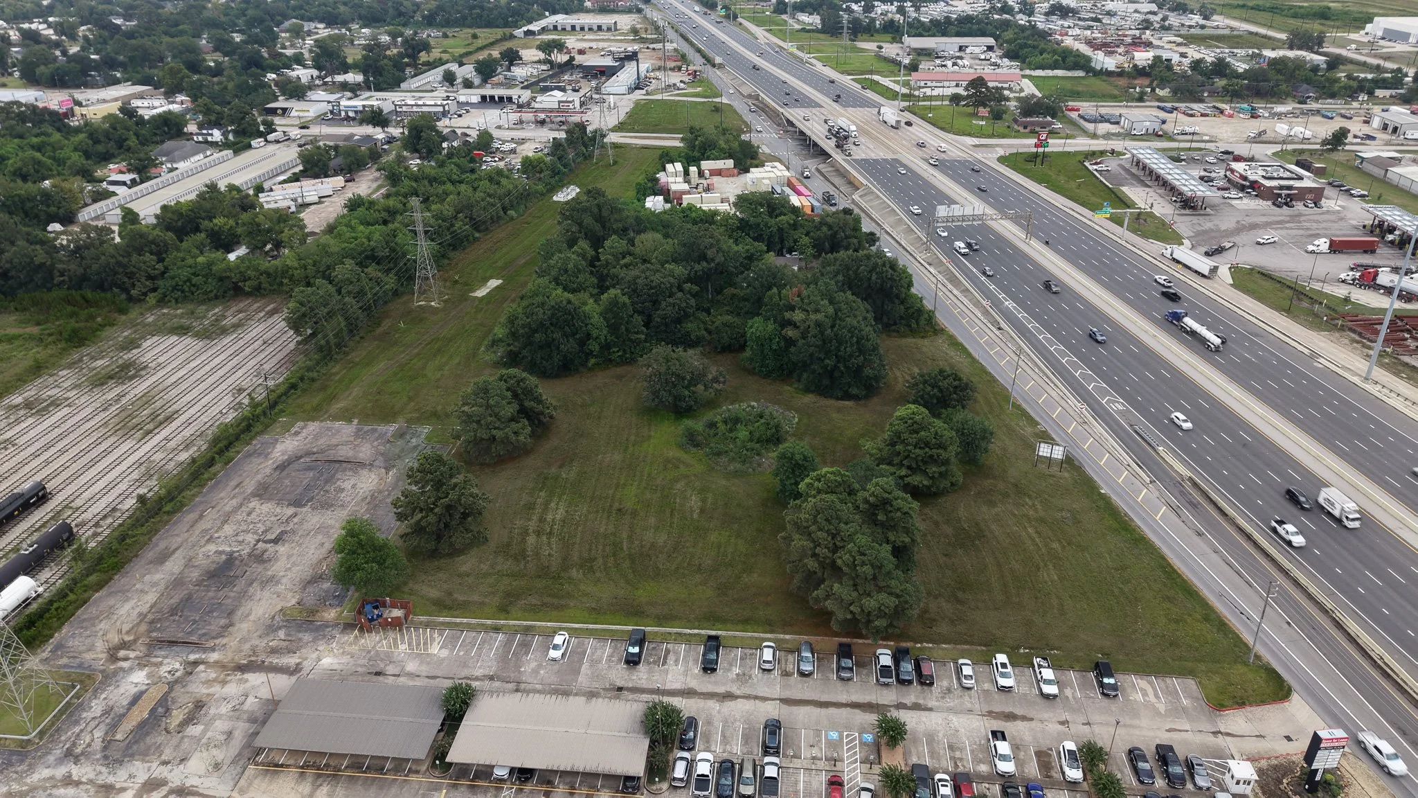 Aerial view of a wooded lot beside a freeway and a parking lot in Channelview, TX