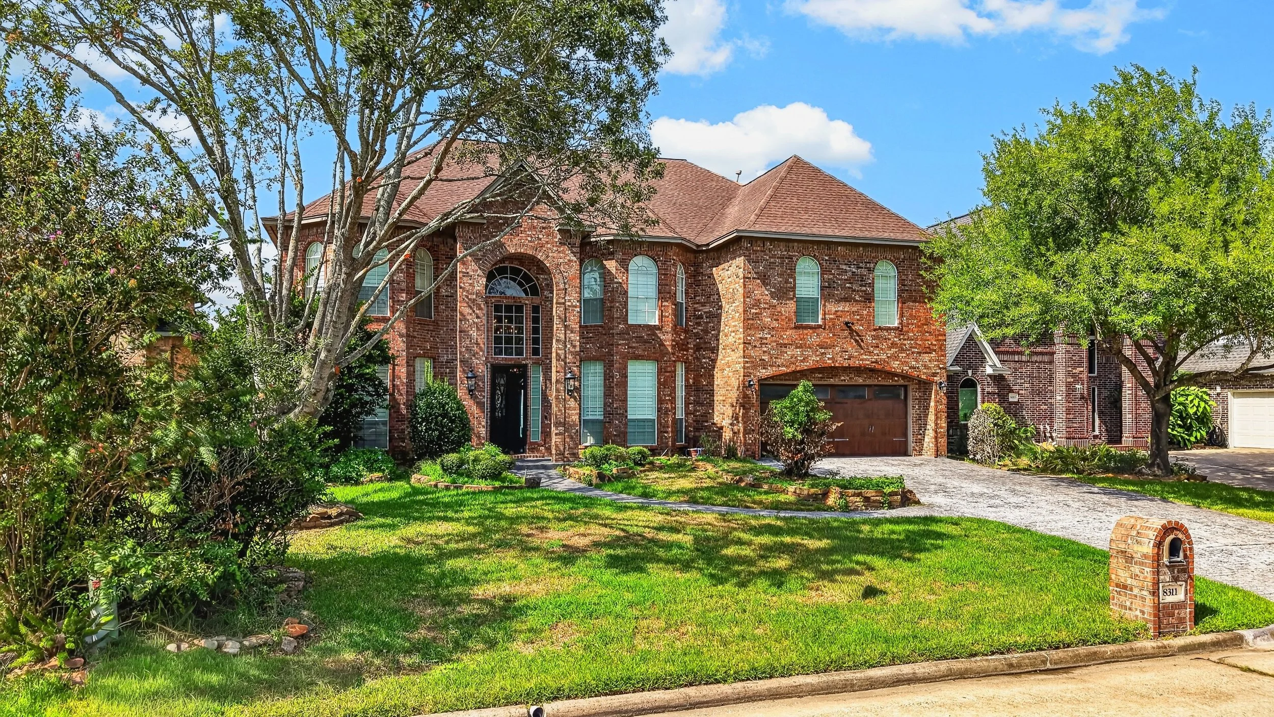 Brick home with arched windows and landscaped front beds