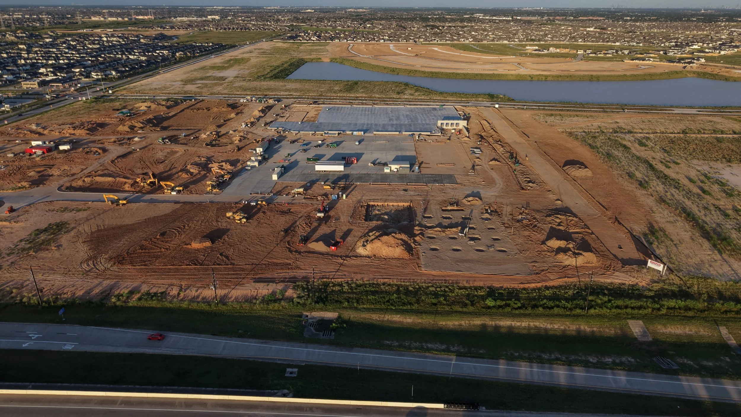 Drone photo of the new Costco under construction on the Grand Parkway in Cypress, TX, in August 2026 showing the poured slab and fuel center footings