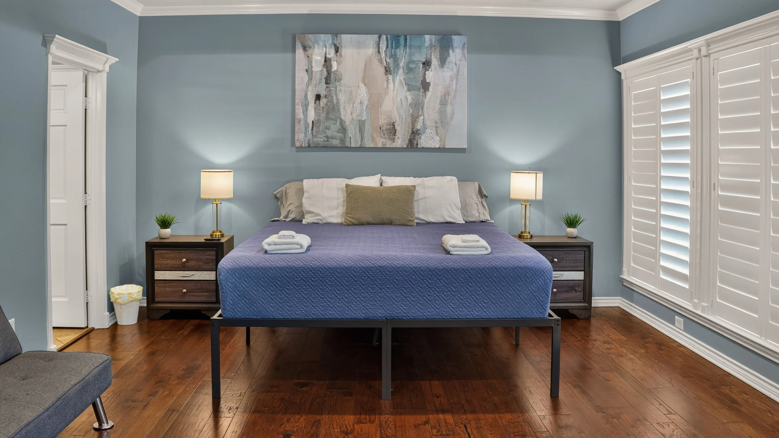 Bedroom with blue bedding and hardwood floors