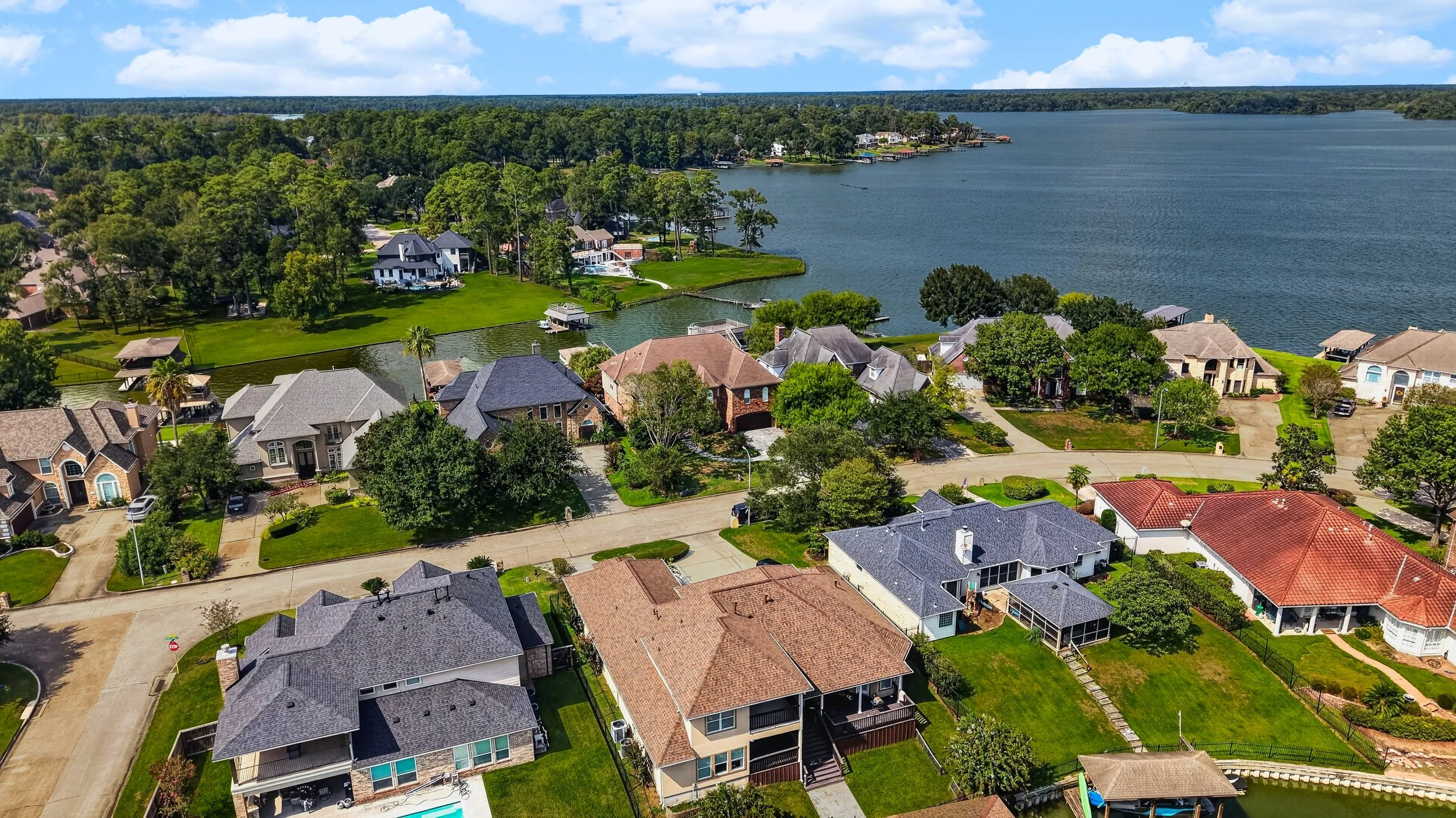 Aerial view of the home with the lake and neighboring waterfront properties